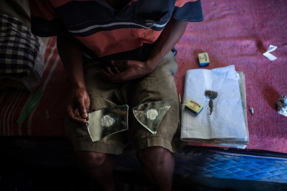 Kwesine, Johannesburg, Sabata Maphela all' interno della su abitazione mente prepara un joint di nyaope, scarti di eroina fumati con marjiuana ©Marco Casino
